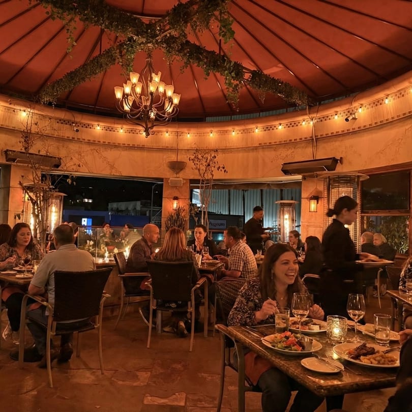 Diners enjoying a lively evening on Anejo Cantina and Grill's outdoor patio under a domed ceiling.