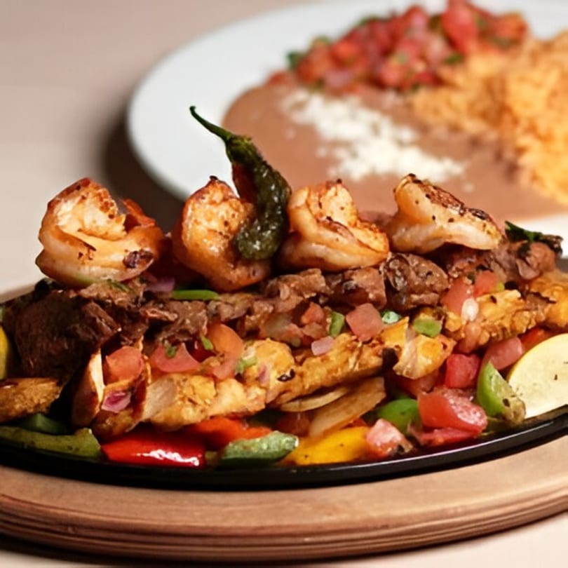 Sizzling Anejo Cantina and Grill fajitas with shrimp, steak, chicken, and colorful vegetables.
